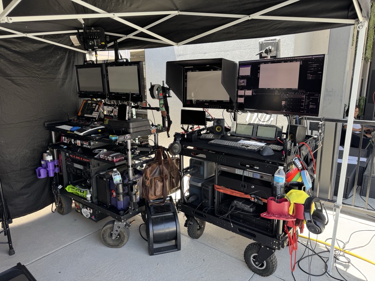 Two production carts configured with monitors, playback controls, image management, audio, and signal-routing equipment beneath a canopy